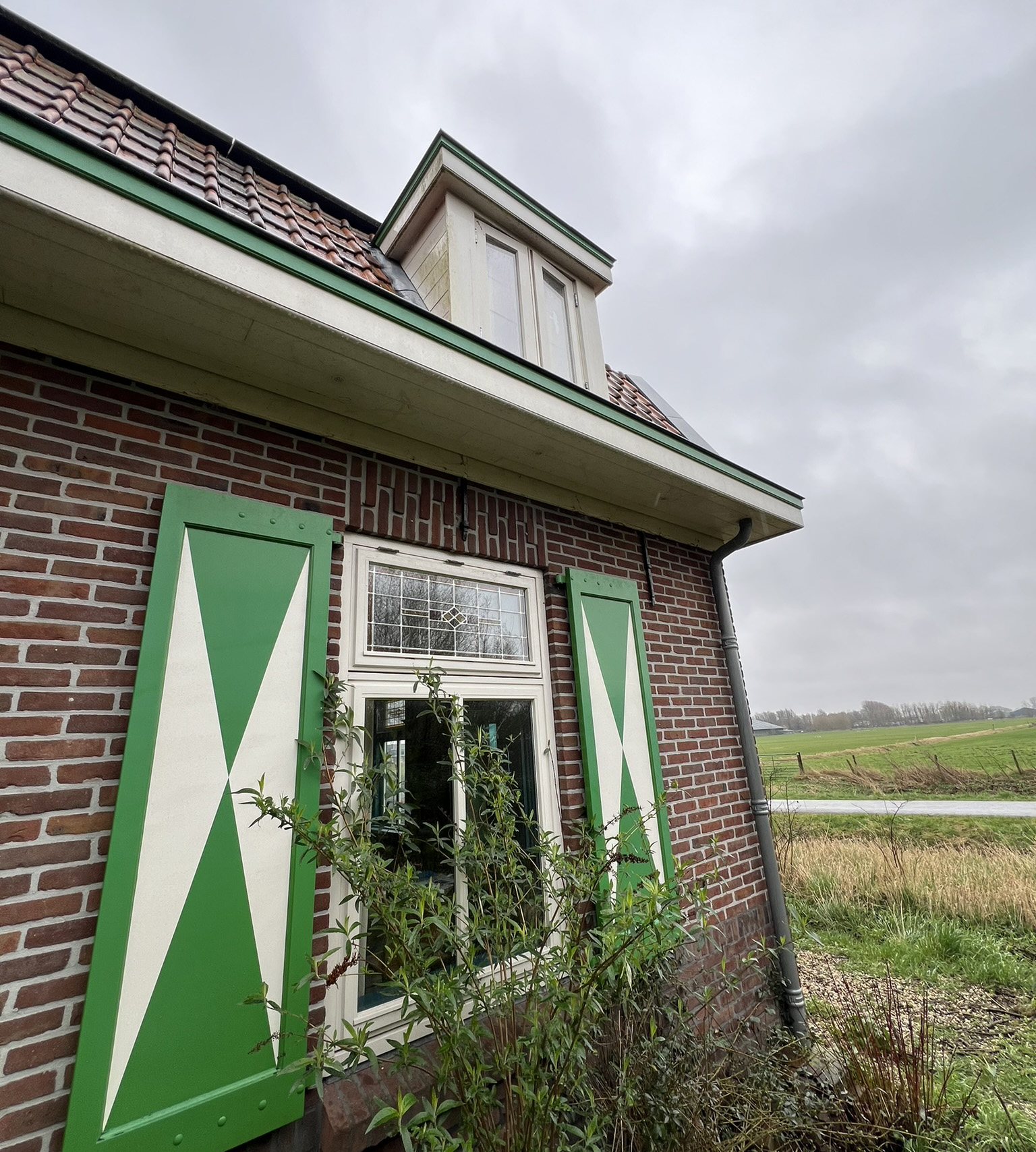Schilderwerk aan woning van Familie van der Ban in Spijkenisse buitenaanzicht gebouw met raam