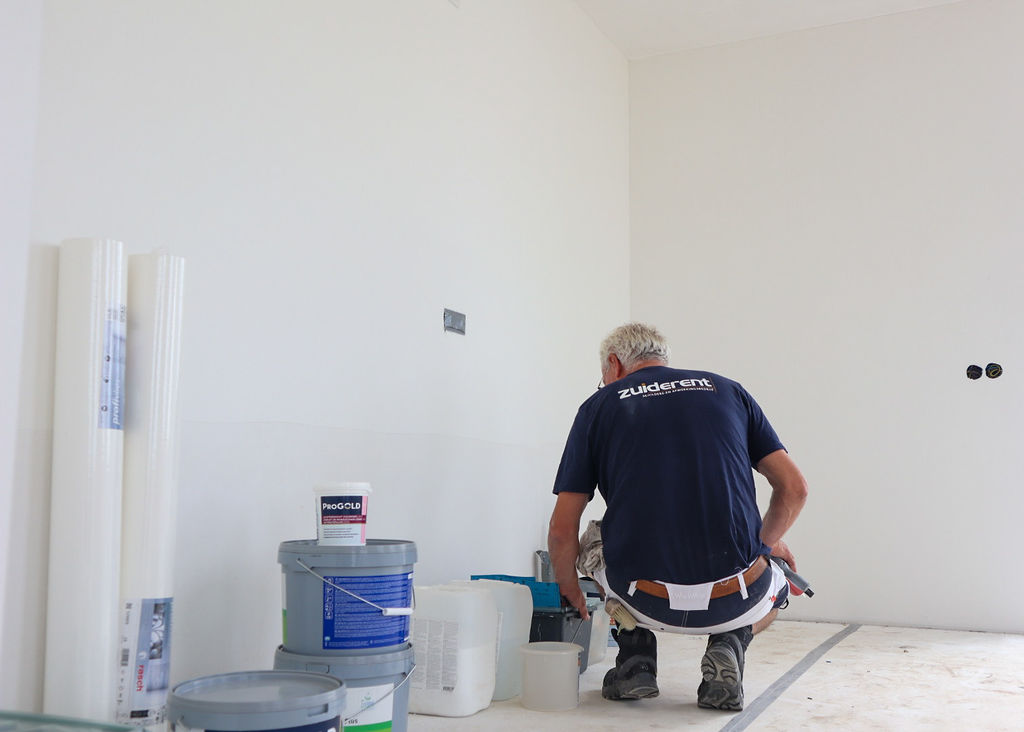 Schilder bereidt materialen voor in een ruimte op locatie